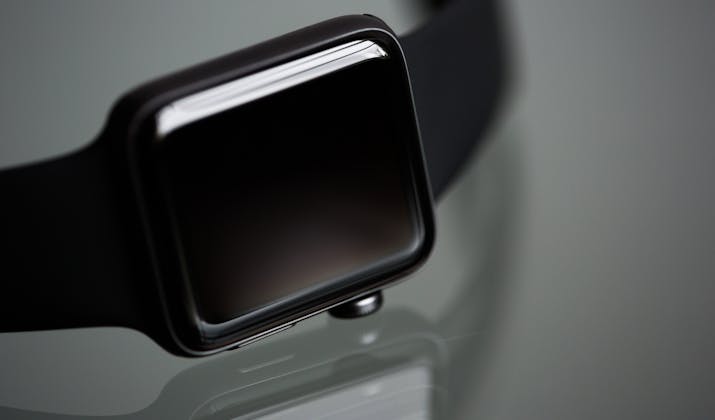 Apple Watch Black Screen - Troubleshooting Tips 2 Black Apple Watch with black band, close-up on a reflective surface.