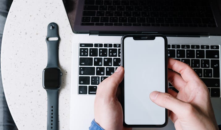 How to Change Your Name on Your Apple Watch 3 Apple Watch placed beside MacBook and iPhone in Apple ecosystem workspace