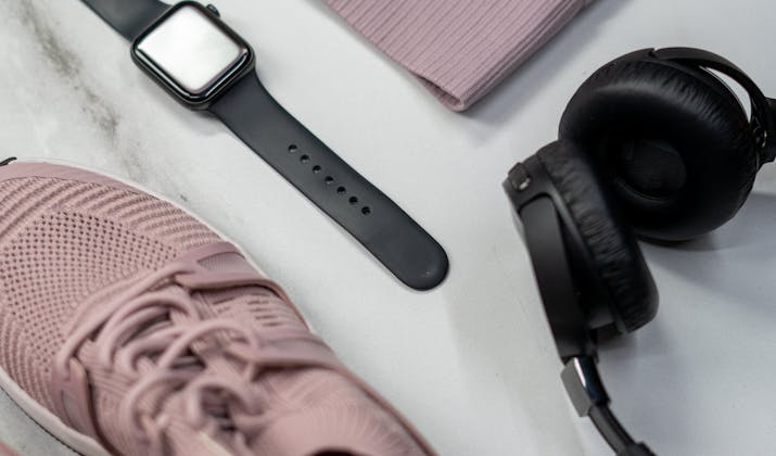 What Is The Apple Watch Walkie Talkie Range? 4 Workout flat lay with Apple Watch, wireless headphones, and pink running shoes