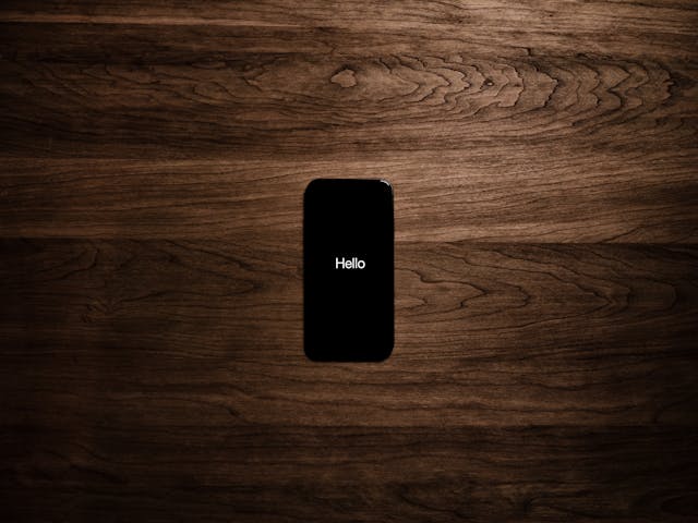 How To Find Hidden Messages On iPhone 3 iPhone in setup with “Hello” screen centered on wooden table