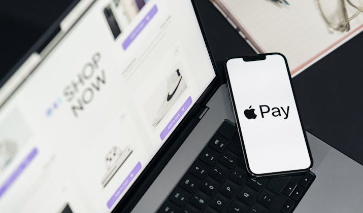 How to Pay Your Subway or Bus Fare with OMNY App 3 iPhone on a laptop keyboard displaying an Apple Pay screen while shopping online.