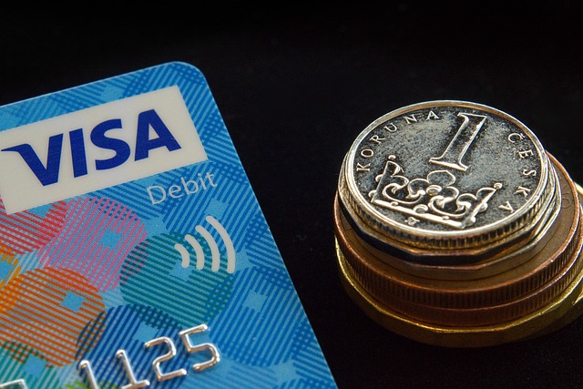 How To Activate Chase Debit Card 3 Close-up of Visa debit card beside stacked coins, illustrating Chase debit card activation and contactless payments.