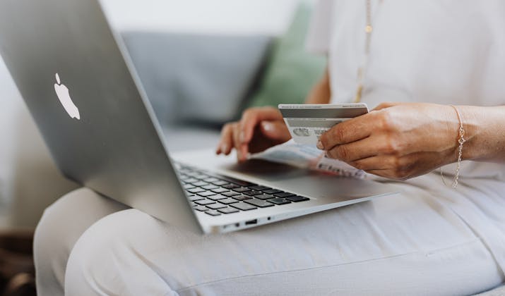 10 Amazon Wish List Search Tips 1 Person shopping online with credit card and Apple MacBook laptop for secure payment