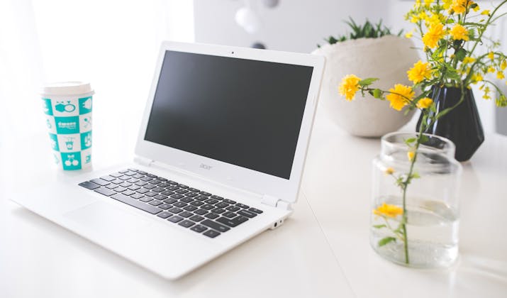 How to Remove Chromebook Management ? 1 White Acer laptop on a desk beside flowers and a coffee cup.