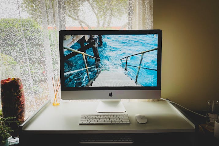 How to Split Your iMac's Fusion Drive 2 Home office setup with Apple iMac and accessories near window