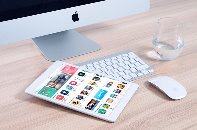 What Comes In The Box While Purchasing iMac 2 iPad with apps beside iMac and mouse