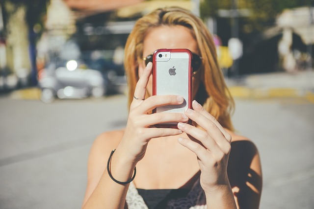How To Keep An App Open On iPhone 3 Woman taking a photo with iPhone on sunny street