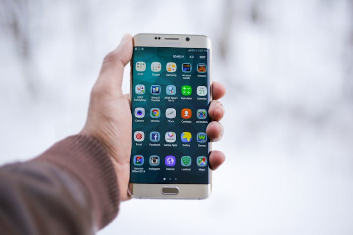 How to Remove OneDrive From Your Samsung Galaxy Note 20 1 Hand holding a Samsung Galaxy smartphone showing the Android home screen