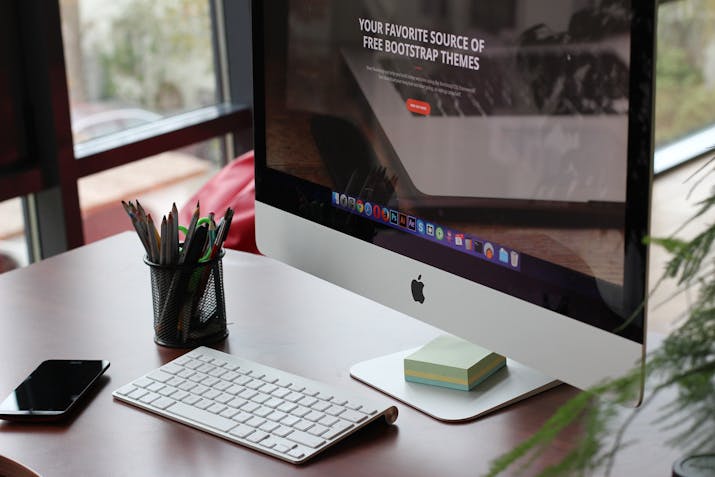 How to Split Your iMac's Fusion Drive 1 Apple iMac desktop workstation with keyboard, mouse and smartphone on desk