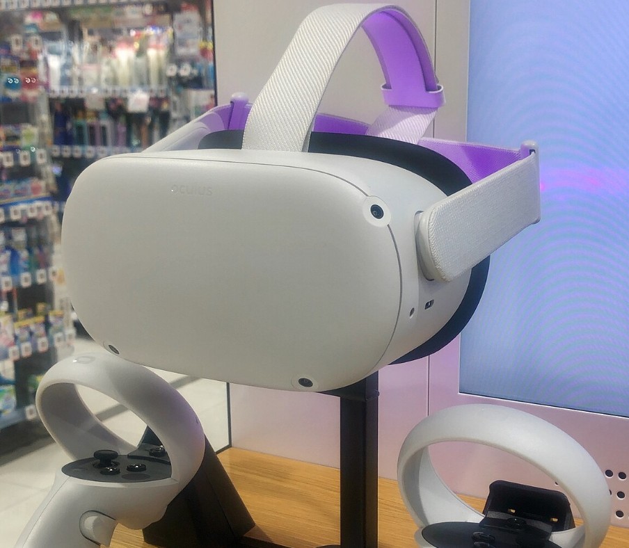 An Oculus Quest 2  headset on a stand in a game store.